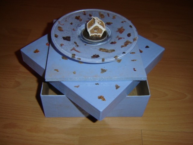 Kovinski lističi uporabljeni na steklu, iverki in na škatli iz papirne mase.