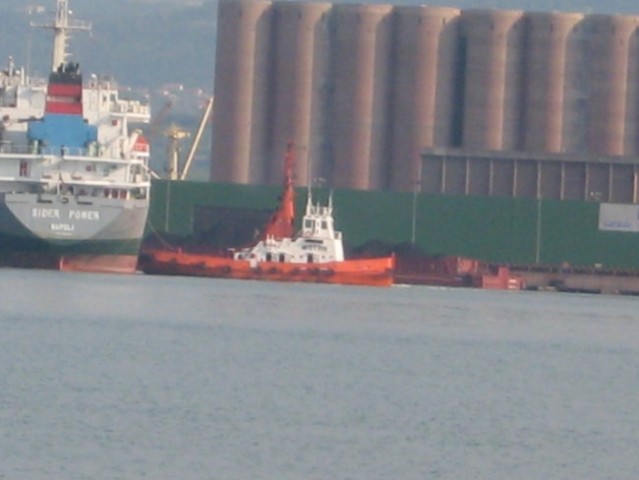 Vlačilec obrača ladjo ki je pripeljala tovor