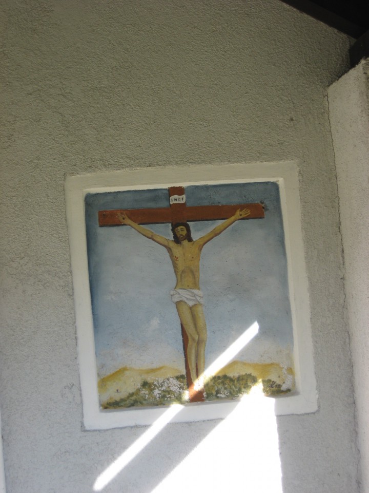 Nazaj grede se ustaviva pri vaški cerkvici: slika na zunanjem zidu