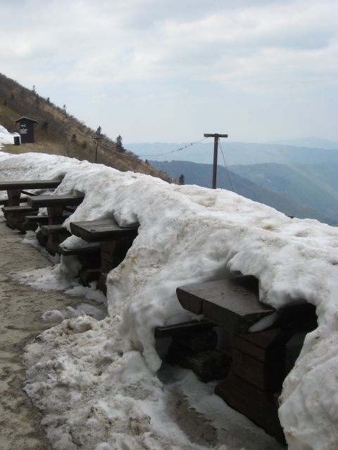 Pred kočo, ki je na severni strani gore se še ni stopil ves sneg