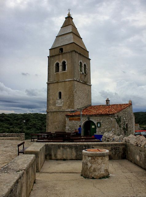 Vodnjak in cerkev z nesorazmerno velikim zvonikom