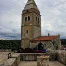 vodnjak in cerkev z nesorazmerno velikim zvonikom