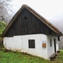 stara hiška s slamnato streho na začetku vzpona na ajdovski gradec