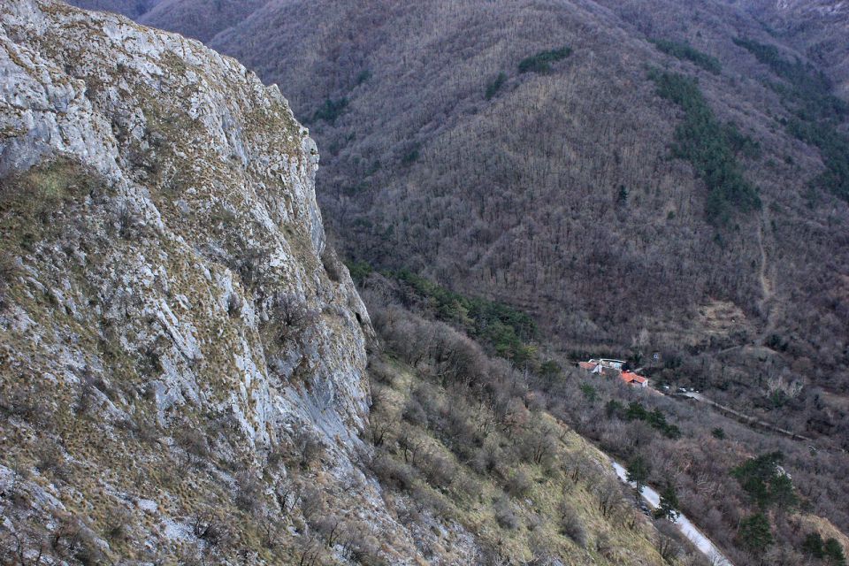 vidi se delček trase železniške proge, čisto spodaj pa osamljen zaselek botač