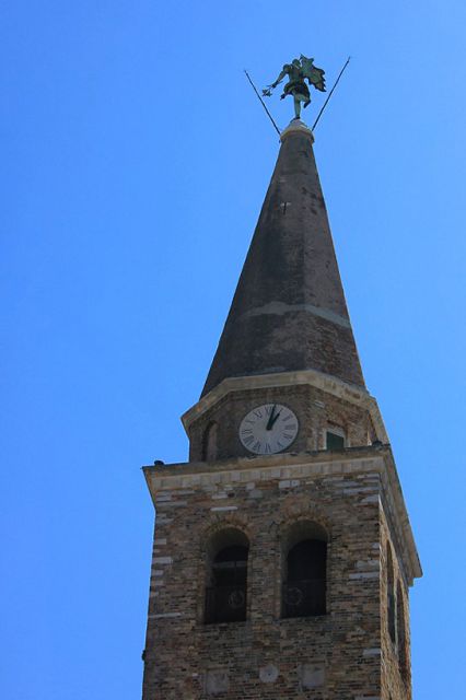 Zvonik, na vrhu katerega je bronasti angel, ki se obrača po vetru...